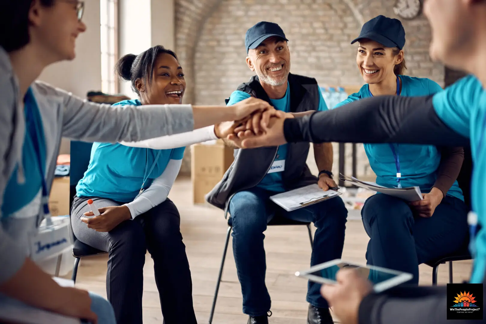 Group of volunteers joining hands together.